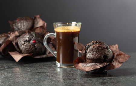 Dark chocolate muffins and cup of black coffee on a black background.の写真素材