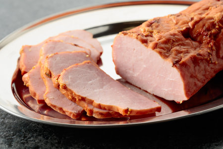 Delicious sliced smoked ham on a metal tray.の写真素材