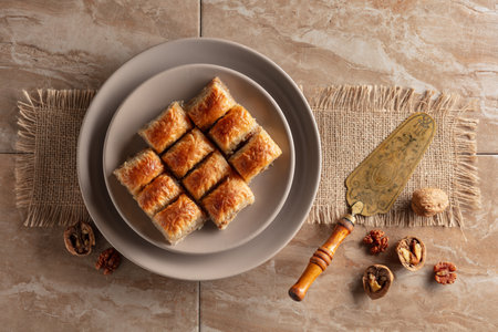 Baklava with walnuts on a beige plate. Top view.