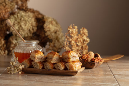 Baklava with walnuts and honey on a beige background. Traditional East desert in wooden dish. Copy space.の写真素材