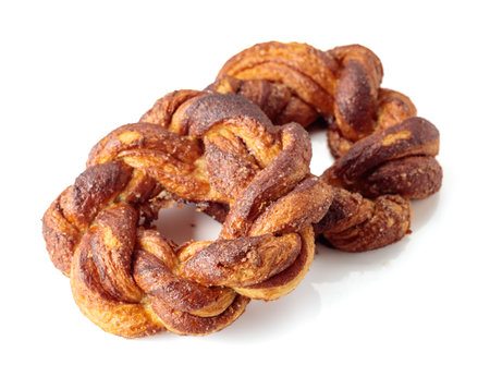 Homemade soft pretzels with cinnamon and sugar isolated on white background. Traditional Scandinavian pastry, popular in Sweden, Norway, Denmark, and Estonia.の写真素材