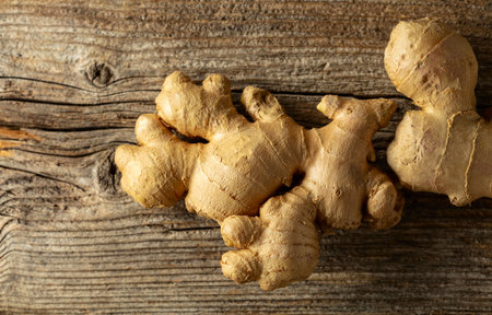 Fresh ginger root on an old wooden board.の写真素材