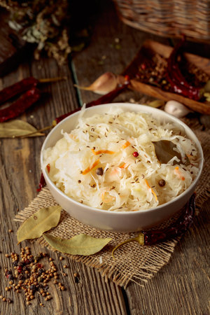 Traditional German sauerkraut with spices on an old rustic wooden table.の写真素材