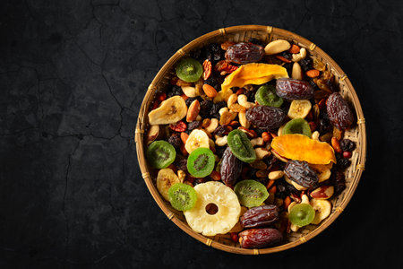 Dried tropical fruits with various nuts and raisins on a black background. Top view.の写真素材