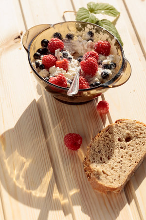 Ricotta or cottage cheese with fresh raspberries and blueberries. A simple country breakfast,...