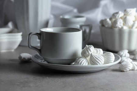 White vanilla meringue and coffee cup on a white marble table.の写真素材