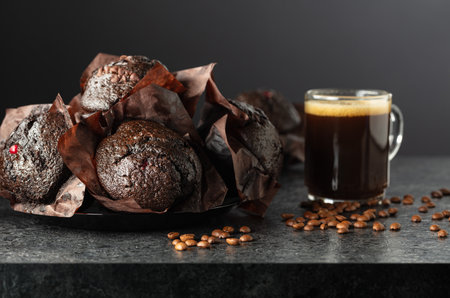 Dark chocolate muffins and cup of black coffee on a black background.の写真素材