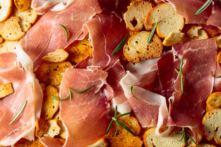 Prosciutto and bruschetta sprinkled with rosemary. Top view. Concept of traditional Italian cuisine.の写真素材