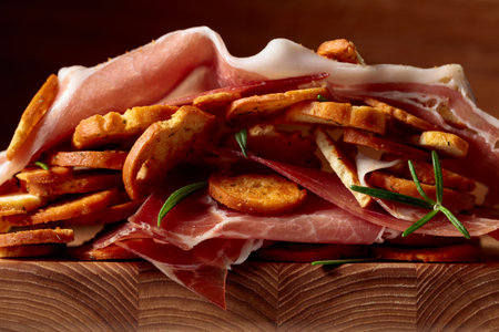 Prosciutto and bruschetta with rosemary. Macro shot. Concept of traditional Italian food.
