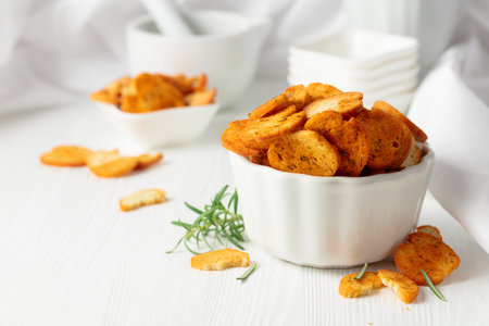 Spicy bruschetta crackers with rosemary on a white kitchen table. Traditional Italian snack.の写真素材