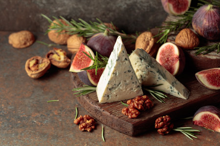 Blue cheese with fresh figs, rosemary, and walnuts on a vintage background.の写真素材