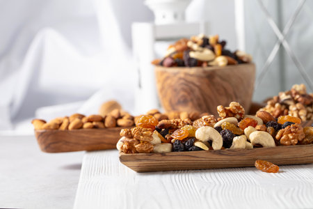 Mix of nuts and raisins on a white wooden table.の写真素材