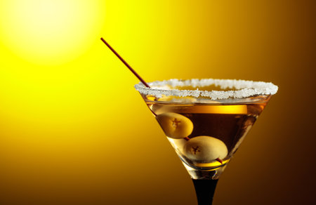Glass of Martini with green olives on a yellow background. Copy space.の写真素材