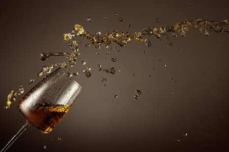 Glass and liquid splash on a beige background. Copy space.の写真素材