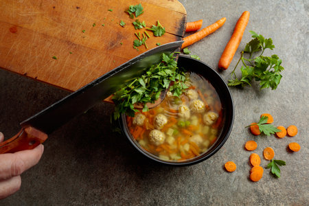 Classic meatball soup with potatoes, carrots and greens. Top view.の写真素材