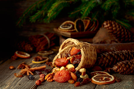 Dried fruits and nuts on an old wooden table. Christmas still-life with dried citrus, apricots, raisins, various nuts, cinnamon sticks, and anise.の写真素材