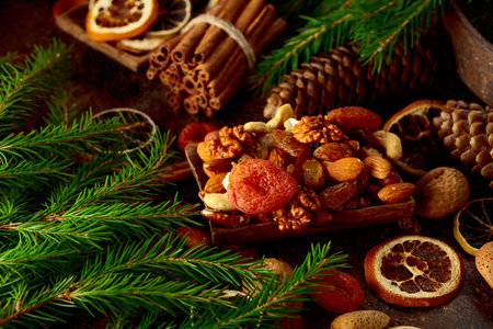 Dried fruits and nuts on a brown vintage background. Christmas still-life with dried citrus, apricots, raisins, various nuts, cinnamon sticks, and anise.の写真素材