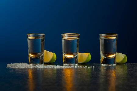 Mexican Tequila with lime and salt on a stone table. Dark blue background with copy space.の写真素材