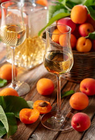 Apricot liqueur or grappa and fresh apricots on an old wooden table.の写真素材