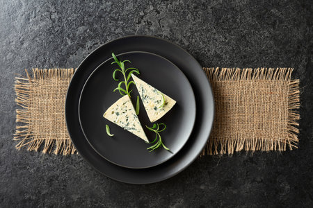 Blue cheese and rosemary on a black plate. Top view. Copy space.の写真素材