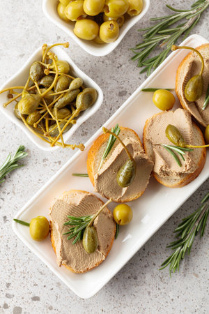 Sandwiches with homemade liver pate with rosemary, capers and green olives. Sandwiches with pate on...