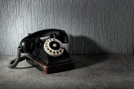 Vintage black phone with rotary dial on a gray stone table. Copy space.の写真素材