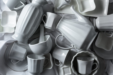 Various white ceramic kitchenware on white fabric. Top view.の写真素材