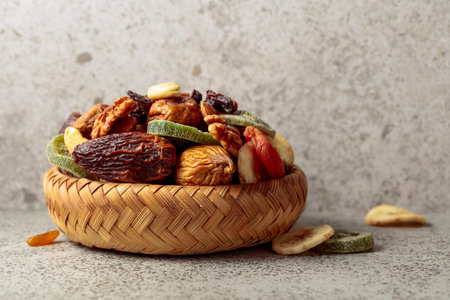 Mix of dried fruits and nuts on a gray stone background. Copy space.