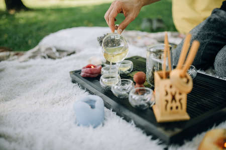 White tea is poured into glass cups. Tea ceremony in the morning in the parkの写真素材