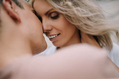 Beautiful couple in smart casual smiling close to each other want to passionately kiss. Portrait of a couple close upの写真素材
