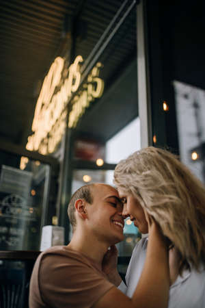 Happy to be in love. Beautiful young couple sitting face to face and smiling while relaxing near a coffee shopの写真素材