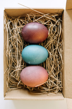 Open parcel with colored Easter eggs. Conceptual holiday top view photoの写真素材