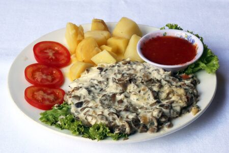 Mushrooms fried in sour cream with boiled potatoes, dishes of Russian national cuisine, restaurant, servingの写真素材