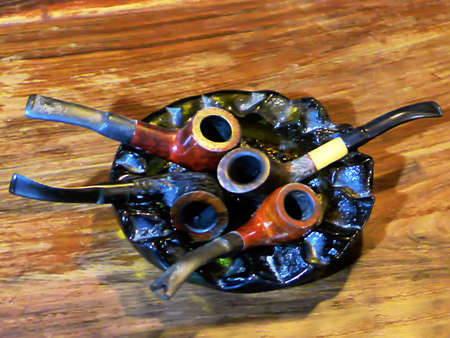 Four smoking pipes in a ashtrayの写真素材