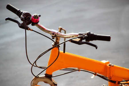 Handlebar and frame of yellow bike on concrete road backgroundの写真素材
