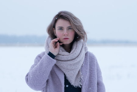 portrait of a beautiful young woman in a pink coatの写真素材