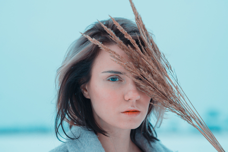 portrait of a beautiful young woman outdoors in a coatの写真素材