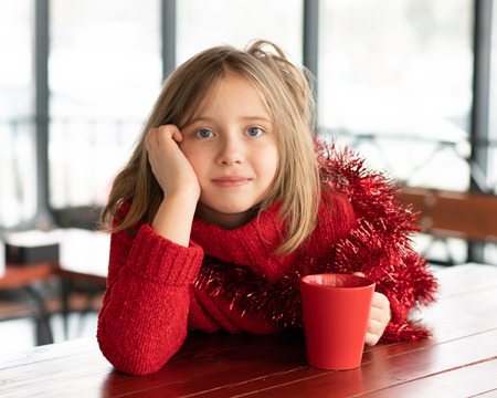 little girl sitting in a cafe at christmasの写真素材