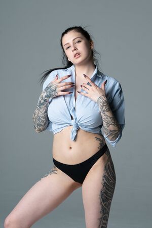 young beautiful girl posing in a blue shirt in the studioの写真素材