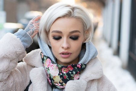 portrait of a girl on the street in a white fur coatの写真素材