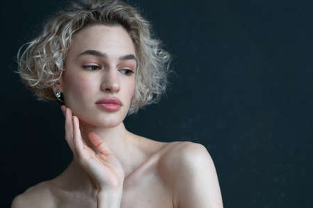 portrait of a woman in the studio near a black wallの写真素材