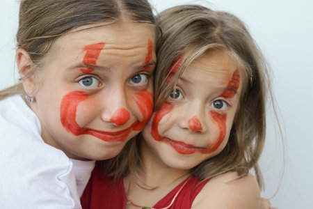 portraits of two little girls stained with paintの写真素材