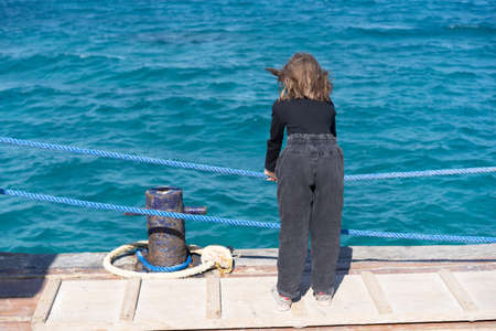 portrait of a little girl with fluffy hair near the seaの写真素材