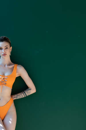 young beautiful woman pose in orange swimsuit in studioの写真素材