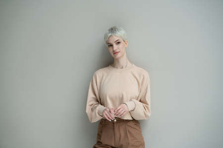 young beautiful woman posing in a beige sweater in the studioの写真素材