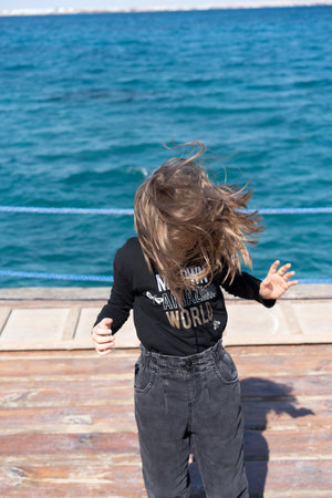 portrait of a little girl with hair stands near the seaの写真素材