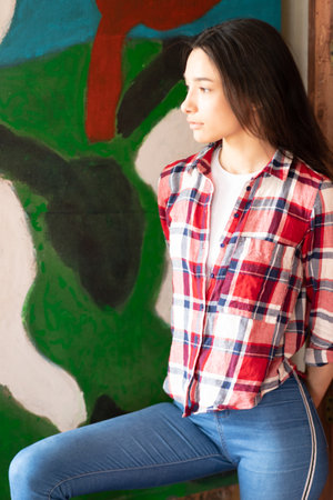 young beautiful woman posing in a plaid red shirt in the studioの写真素材