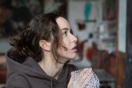 Portrait of a beautiful young woman with long brown hair in a gray hoodieの写真素材