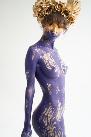 young beautiful girl posing nude in studio with body painting on her bodyの写真素材