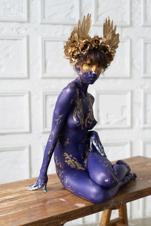 Naked woman with a golden crown on her head and body.の写真素材